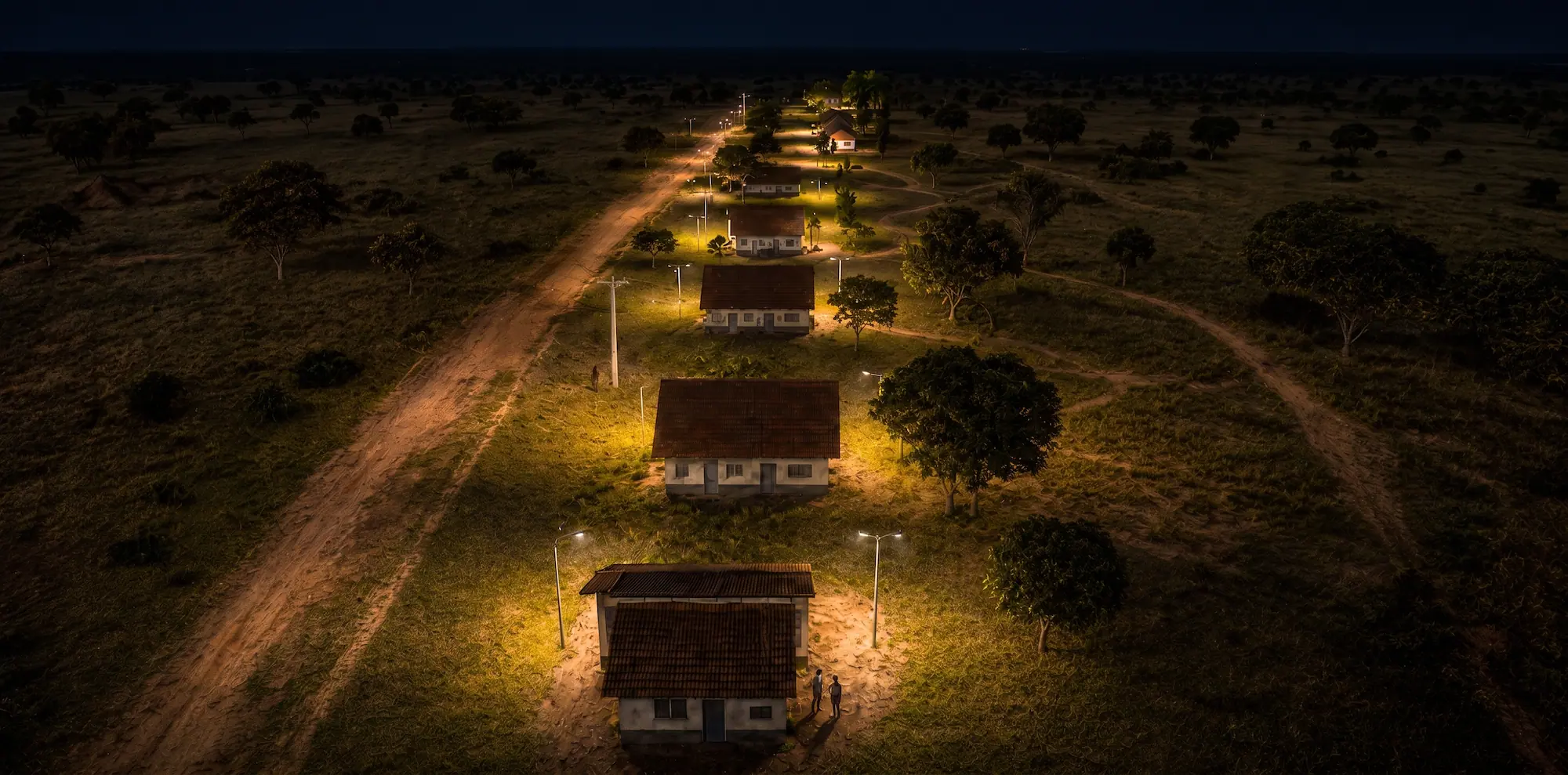 Refeitório e áreas comuns do retiro rural iluminados durante a noite.